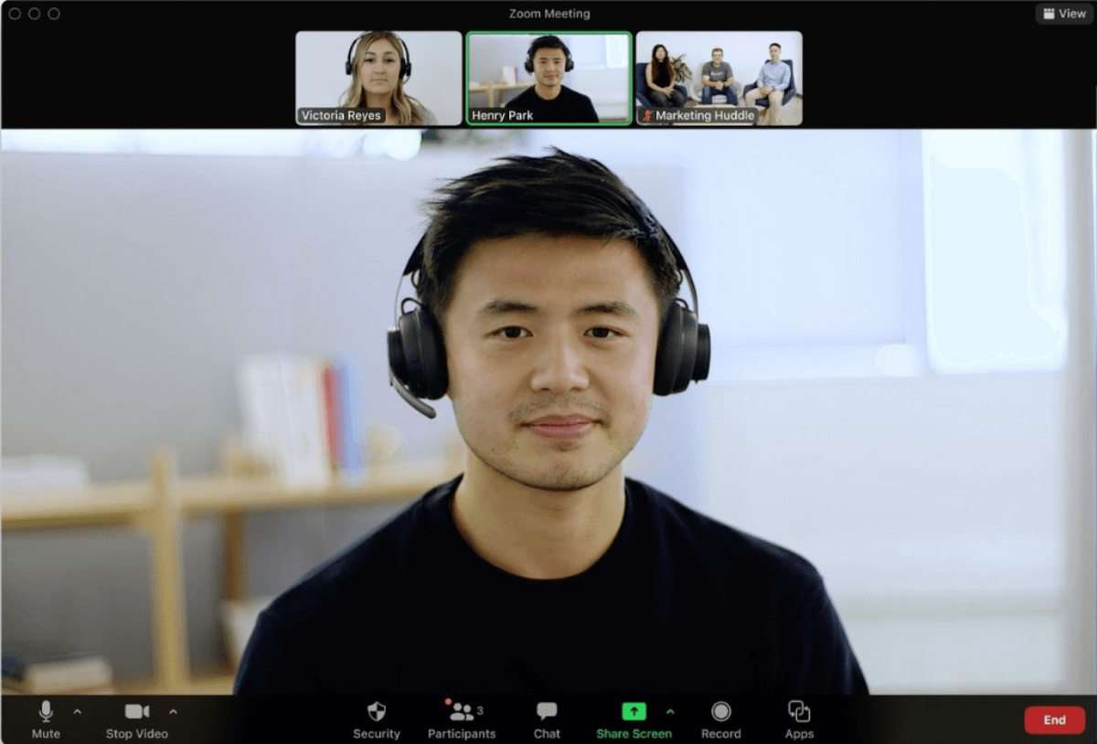 A man wearing headphones and a headset engaged in a video call on Zoom